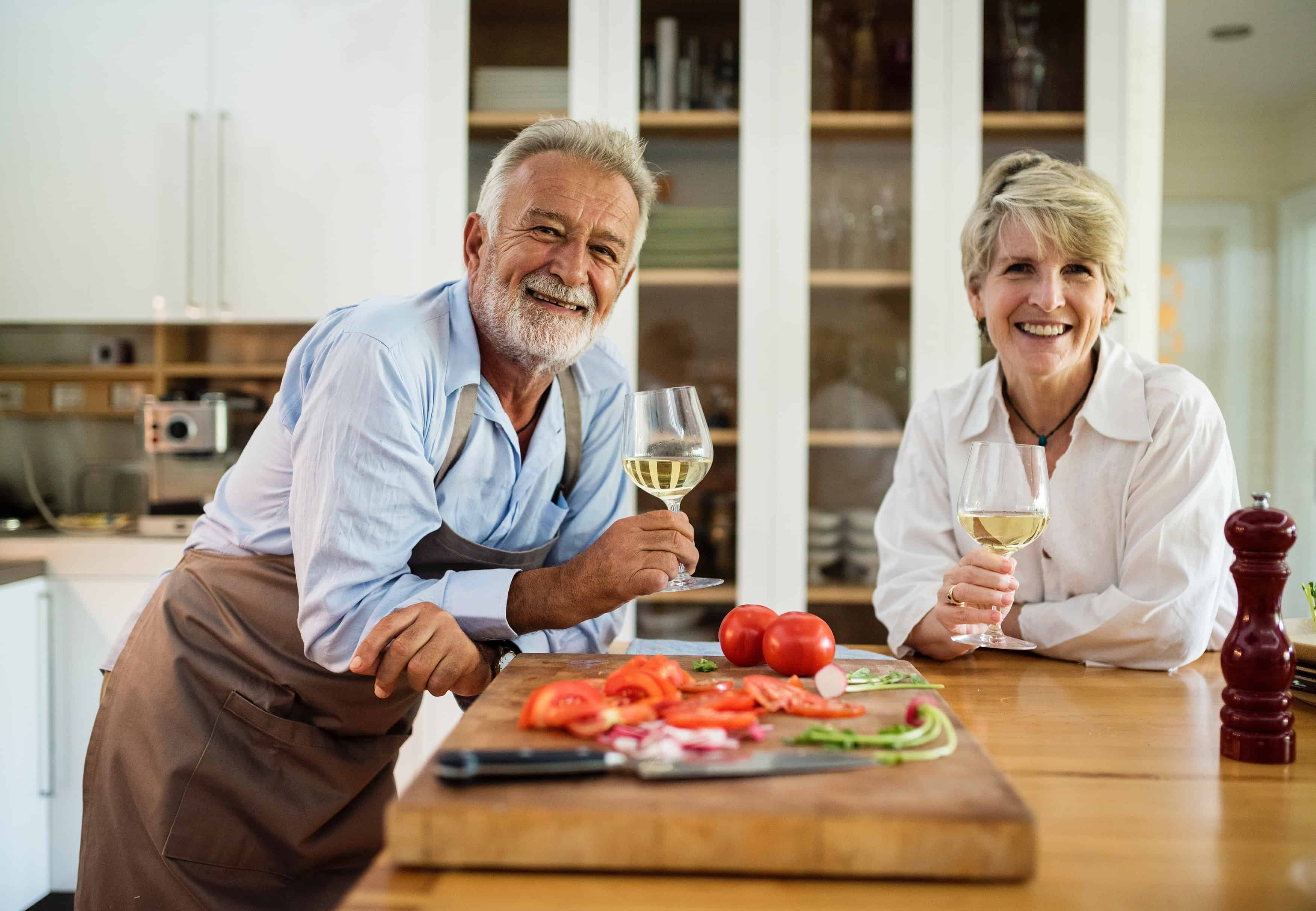Baby boomers drink wine and smile at the camera