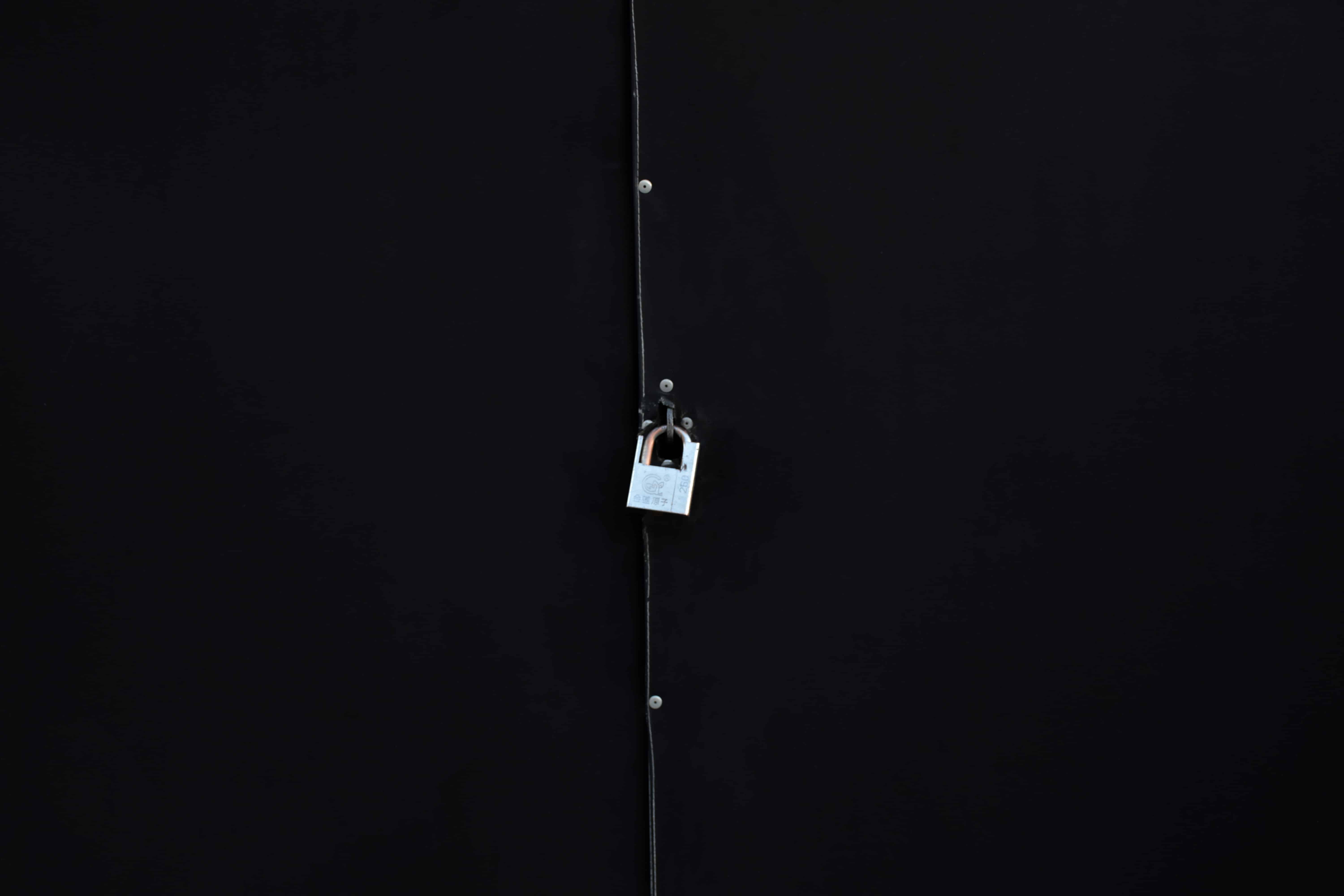 A padlock on a black door